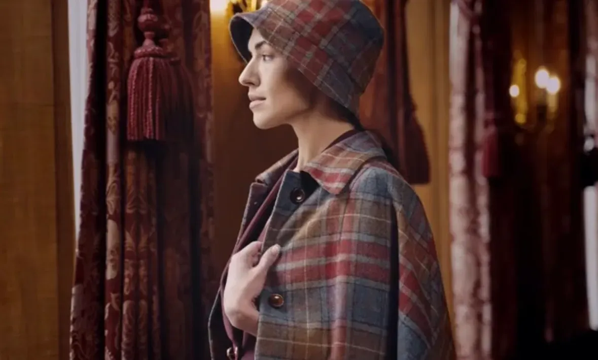 Close profile portrait of the plaid wool bucket hat and cape