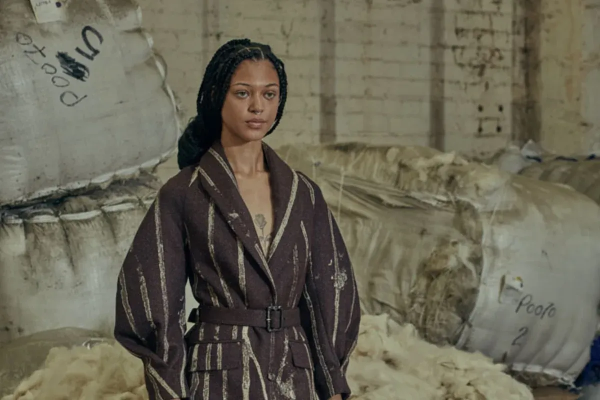Portrait in the striped wool overcoat among raw wool bales