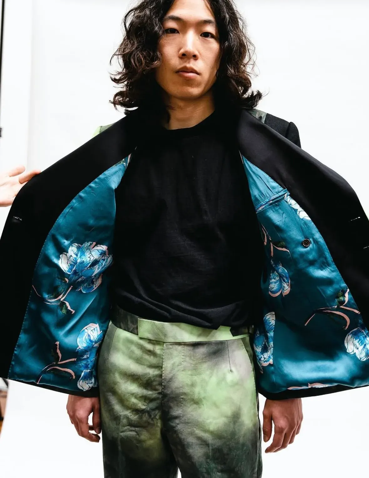 Tie-dye green double-breasted jacket worn open, revealing a floral silk lining