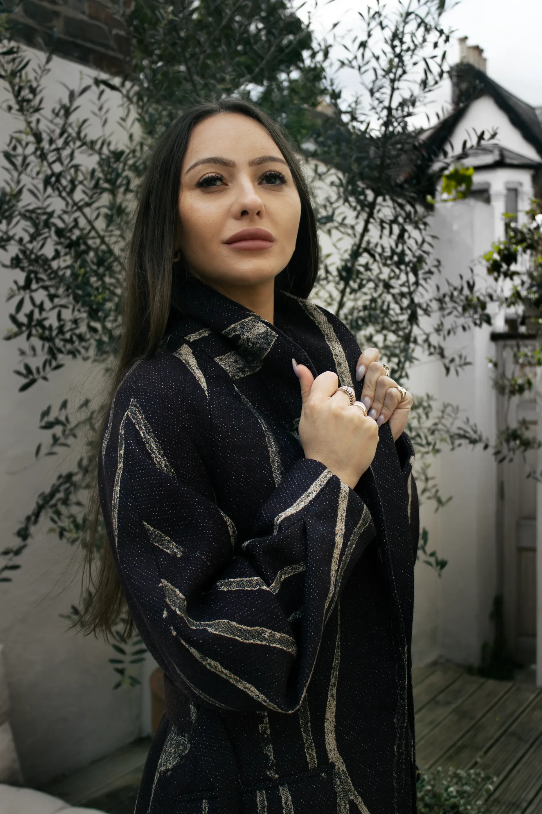 Portrait in the dark striped and belted tailored coat